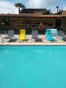 een groep stoelen naast een zwembad bij Your HOME ECO & NATUR in Carvide