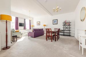 a living room with a table and chairs at The Cross Keys Market Street Apartment - Sleeps 6 in St. Andrews