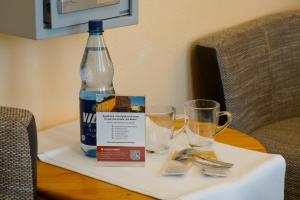 a bottle of water and two glasses on a table at Hotel Zur Mühle in Kappeln