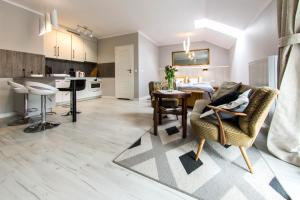 kuchnia i salon ze stołem i krzesłami w obiekcie Apartamenty Izerskie - ul. Cicha 13H-I w Świeradowie Zdroju