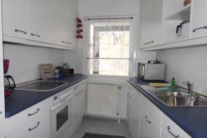 una cucina con mobili bianchi, un lavandino e una finestra di Ferienwohnung Simon a Braunlage Altre 2 foto