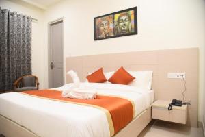 una camera da letto con un grande letto con una coperta arancione di Hotel Hamilton a Zirakpur