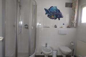 een badkamer met een douche, een toilet en een wastafel bij Ferienwohnung Simon in Braunlage
