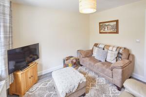 a living room with a couch and a flat screen tv at Host & Stay - Carlewell Cottage in Middlesmoor