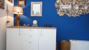 um quarto com uma parede azul com uma cómoda e um espelho em Ferienwohnung Kleine Auszeit em Ostseebad Sellin