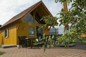 ein gelbes Haus mit einem Tisch und Stühlen in der Unterkunft Ferienwohnung Schwalbennest am Igelsbachsee in Absberg