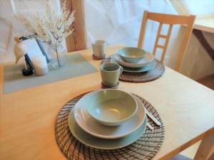 einem Tisch mit Tellern und Tassen auf einem Holztisch in der Unterkunft Ferienwohnung Schwalbennest am Igelsbachsee in Absberg