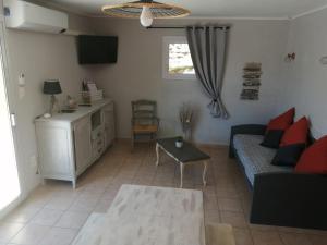 ein Wohnzimmer mit Sofa und Tisch in der Unterkunft Gîtes de l'Esquirou in Lagorce