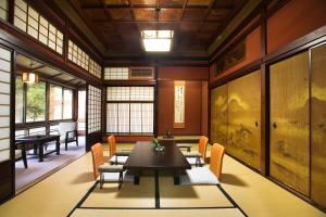a room with a table and chairs and windows at Motoyu Ishiya in Kanazawa