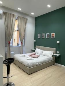 a bedroom with a bed with a green wall at NSH AppartHotel, Napoli Centro in Naples