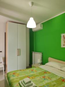 Dormitorio verde con cama y pared verde en Prima Luce, en Nova Siri