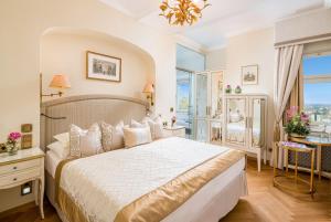 a bedroom with a large bed and a large window at Hotel Schloss Mönchstein in Salzburg