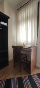 a desk and chair in a room with a window at Андреева къща in Zlatograd