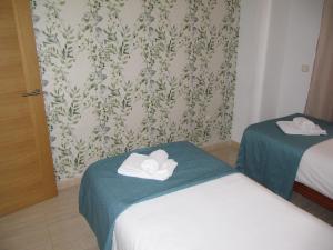 a room with two beds with towels on them at Life Apartments Alameda Colón in Málaga