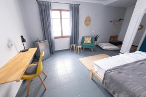 Schlafzimmer mit einem Bett, einem Schreibtisch und Stühlen in der Unterkunft Casa de Océano in Tarifa