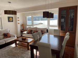 a living room with a dining room table and chairs at Rompeolas in Laxe