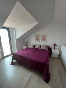 a bedroom with a large purple bed with two lamps at Quinta De Santana in Rabo de Peixe