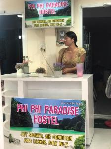 Una mujer parada detrás de un mostrador en una peluquería en Phi Phi Paradise Hostel, en Islas Phi Phi