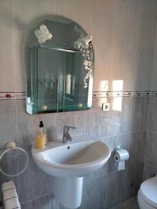 ein Badezimmer mit einem Waschbecken, einem Spiegel und einem WC in der Unterkunft La Casa del Limonero in Suances