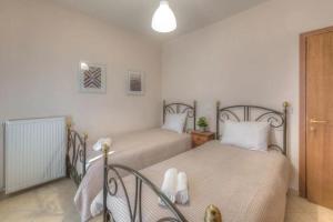 a bedroom with two beds with white pillows at Gerania Villa in Písia