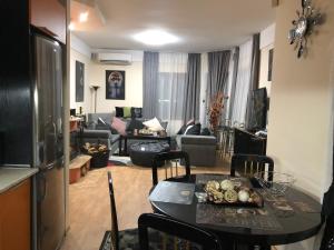 a living room with a table and a couch at Sunshine villa Dzhigurovo in Sandanski
