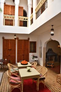 馬拉喀什的住宿－蘭齊亞庭院旅館，客厅配有桌椅和壁炉