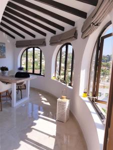 a white room with a table and windows at Renovierte Villa mit privatem Pool fußläufig zum Meer in Benissa