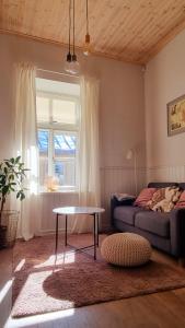 ein Wohnzimmer mit einem Sofa, einem Tisch und einem Fenster in der Unterkunft Villa Frieda in Haapsalu