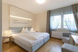 una camera d'albergo con letto e sedia di Hotel im Auerbachtal a Bad Laasphe