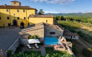 an external view of a villa with a swimming pool at Elegant Villa wing of Castello di Cacchiano by VacaVilla in Monti di Sotto
