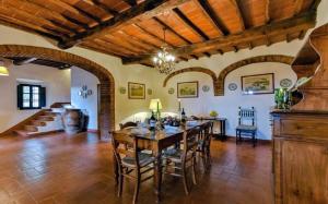 a large dining room with a wooden table and chairs at Elegant Villa wing of Castello di Cacchiano by VacaVilla in Monti di Sotto