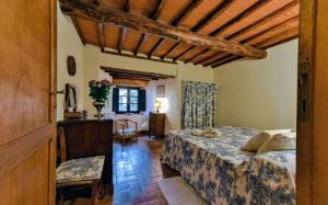a bedroom with a bed and a table in a room at Elegant Villa wing of Castello di Cacchiano by VacaVilla in Monti di Sotto +28 photos