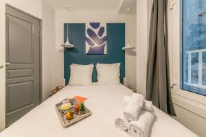 Un dormitorio con una cama con una bandeja de comida. en Apartments WS Champs-Elysées - Colomb en París