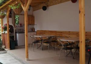 une cuisine avec des tables et des chaises sur une terrasse dans l'établissement Къща за гости Хриси, à Velingrad