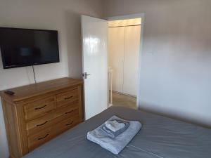 a bedroom with a bed and a flat screen tv at Froden Court in Billericay