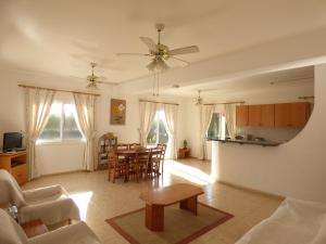 a living room with a table and a dining room at Villa Isabella: Coral Bay Beach, Seaview in Peyia