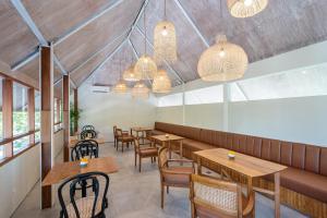 a restaurant with wooden tables and chairs and lights at Ecozy Dijiwa Canggu in Canggu