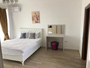 - une chambre avec un lit blanc et un miroir dans l'établissement REYNA APART HOTEL, à Constanţa