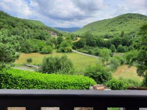 einen Balkon mit Blick auf ein Feld und die Berge in der Unterkunft Val Paradis in Espagnac-Sainte-Eulalie