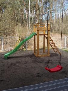 een schommel in een speeltuin met een glijbaan bij Bochenówka in Rogowo