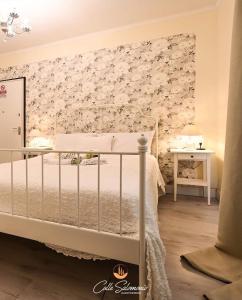 Un dormitorio con una cama con una pared de acento floral en Agriturismo Colle Salomonio, en Nepi