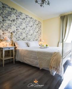 1 dormitorio con 1 cama con pared de flores en Agriturismo Colle Salomonio, en Nepi