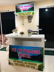 a sign for a phill ph palatable hostel on a table at Phi Phi Paradise Hostel in Phi Phi Don