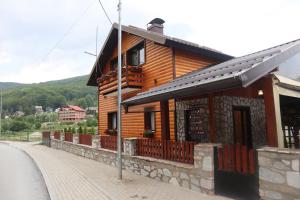 a wooden house on the side of a street at Villa Beti in Mavrovo +51 photos