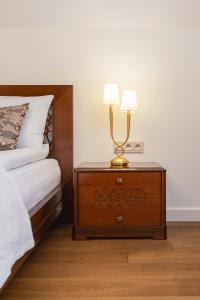 a nightstand with a lamp on it next to a bed at Apartament Lux Rezydencja Tatry by Renters Prestige in Zakopane