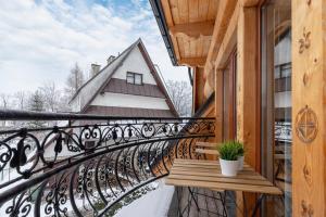 a balcony with a bench and a house at Apartament Lux Rezydencja Tatry by Renters Prestige in Zakopane