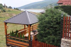 een tuinhuisje met een metalen dak naast een hek bij Villa Beti in Mavrovo
