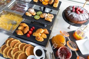 uma mesa coberta com diferentes tipos de alimentos em bandejas em Petit Palace Arana Bilbao em Bilbao