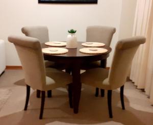 a dining room table with four chairs around it at Life on Water- Princes Wharf apartment with fabulous views in Auckland