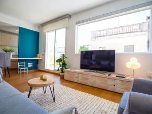 a living room with a large flat screen tv at Elite Bonaire Penthouse by Hello Homes Sitges in Sitges